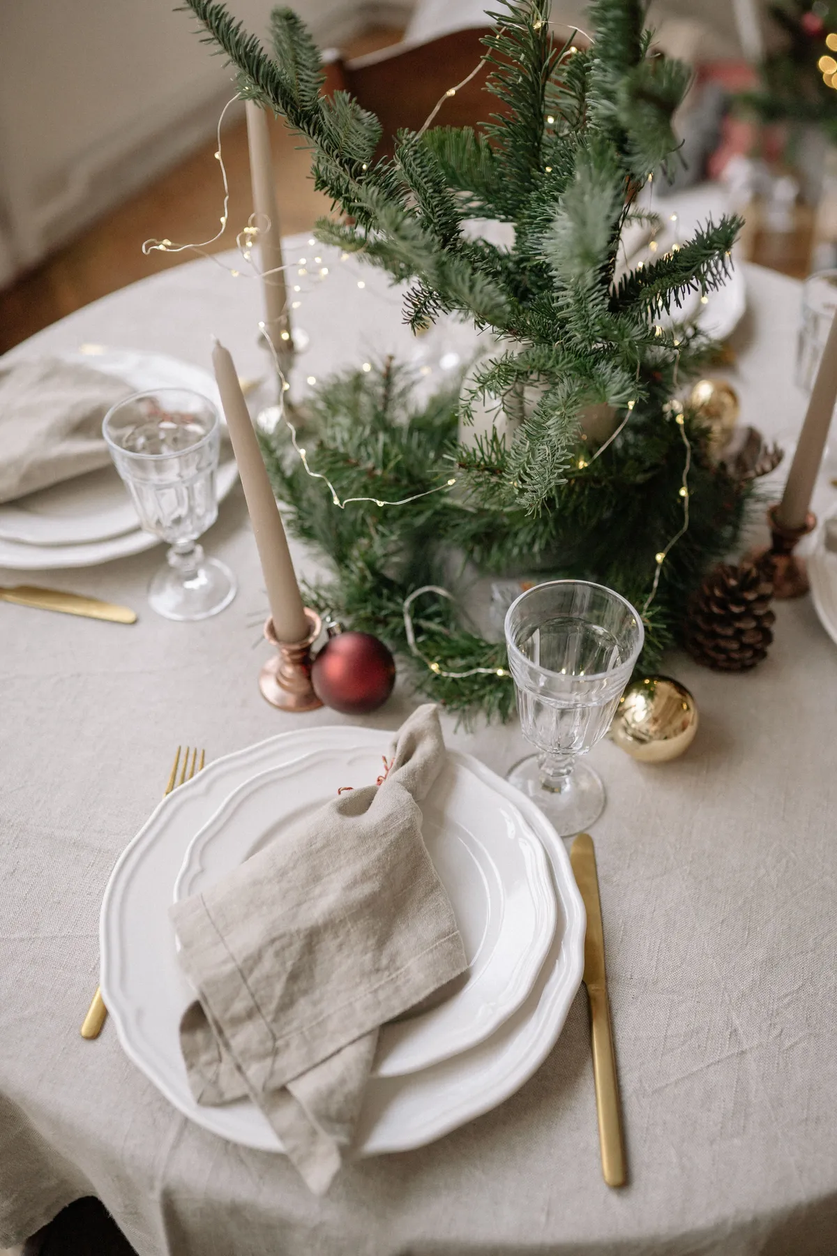 A beautifully decorated table with Christmas ornaments and candles creating a festive atmosphere.