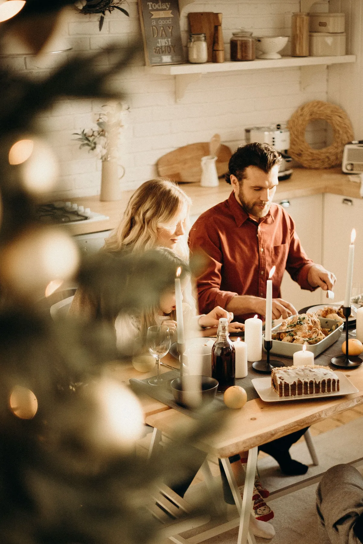 A cozy family dinner setting with festive decorations during the holiday season in a warmly lit room.