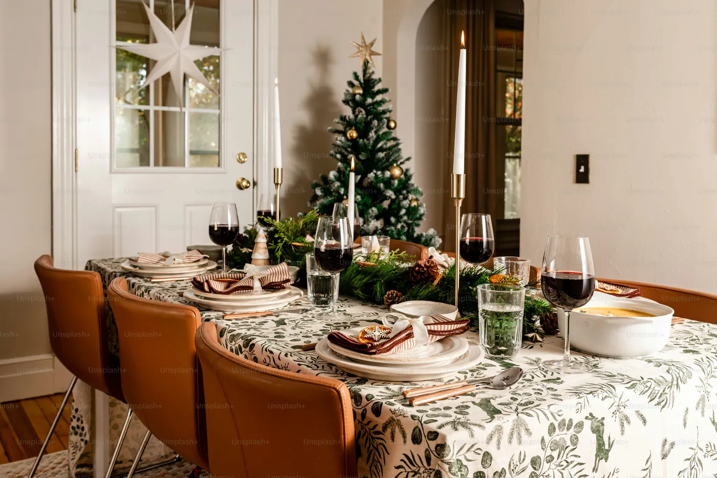 A dining room table with a christmas tree in the background - Photo on  Unsplash+