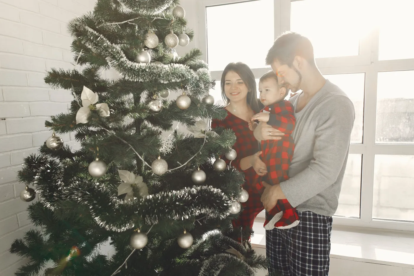 A family gathered around a Christmas tree, celebrating the festive season indoors.