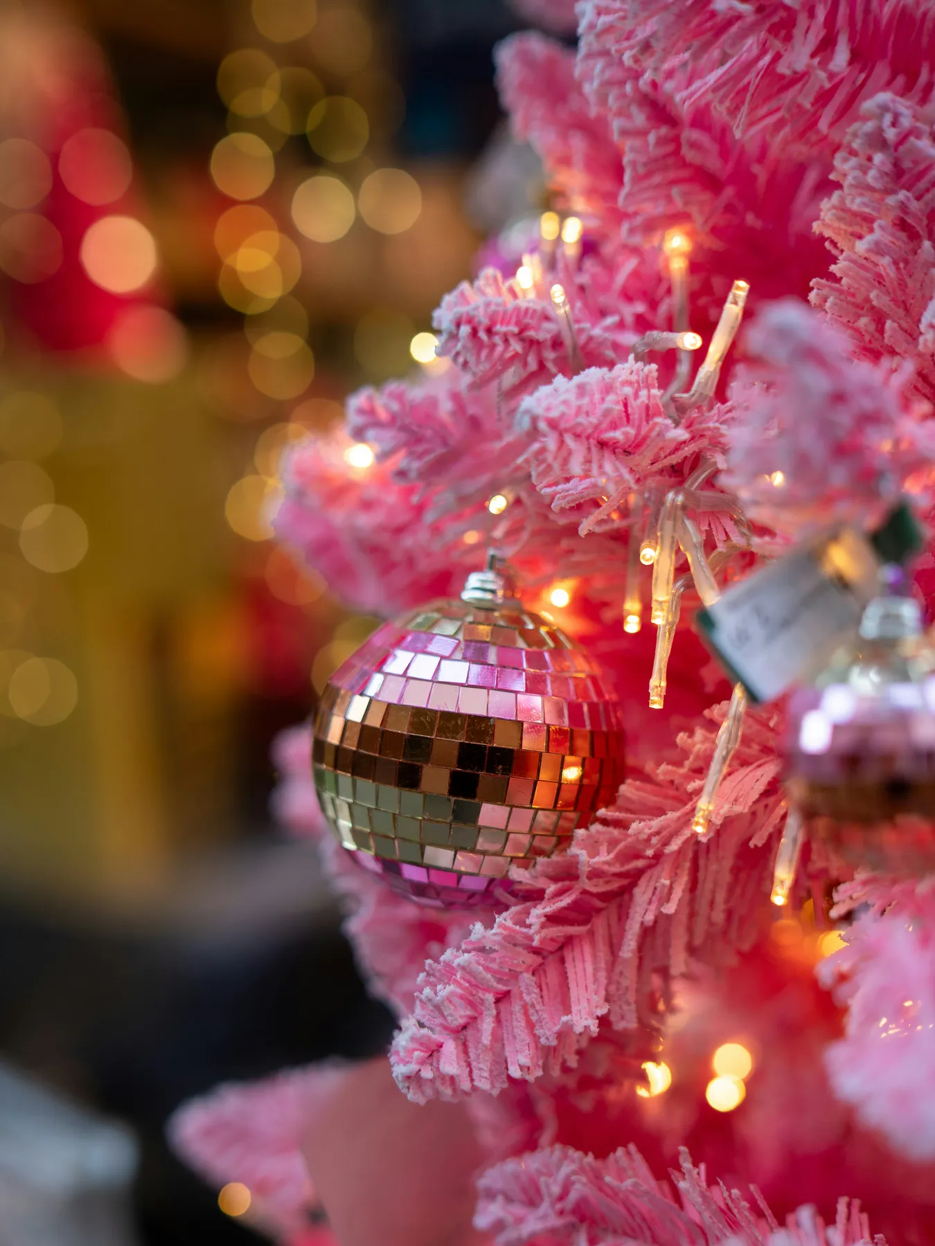 A pink christmas tree with disco ball ornaments
