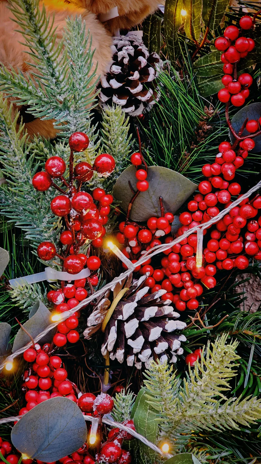 A vibrant garland with red berries and pinecones, perfect for holiday decor.
