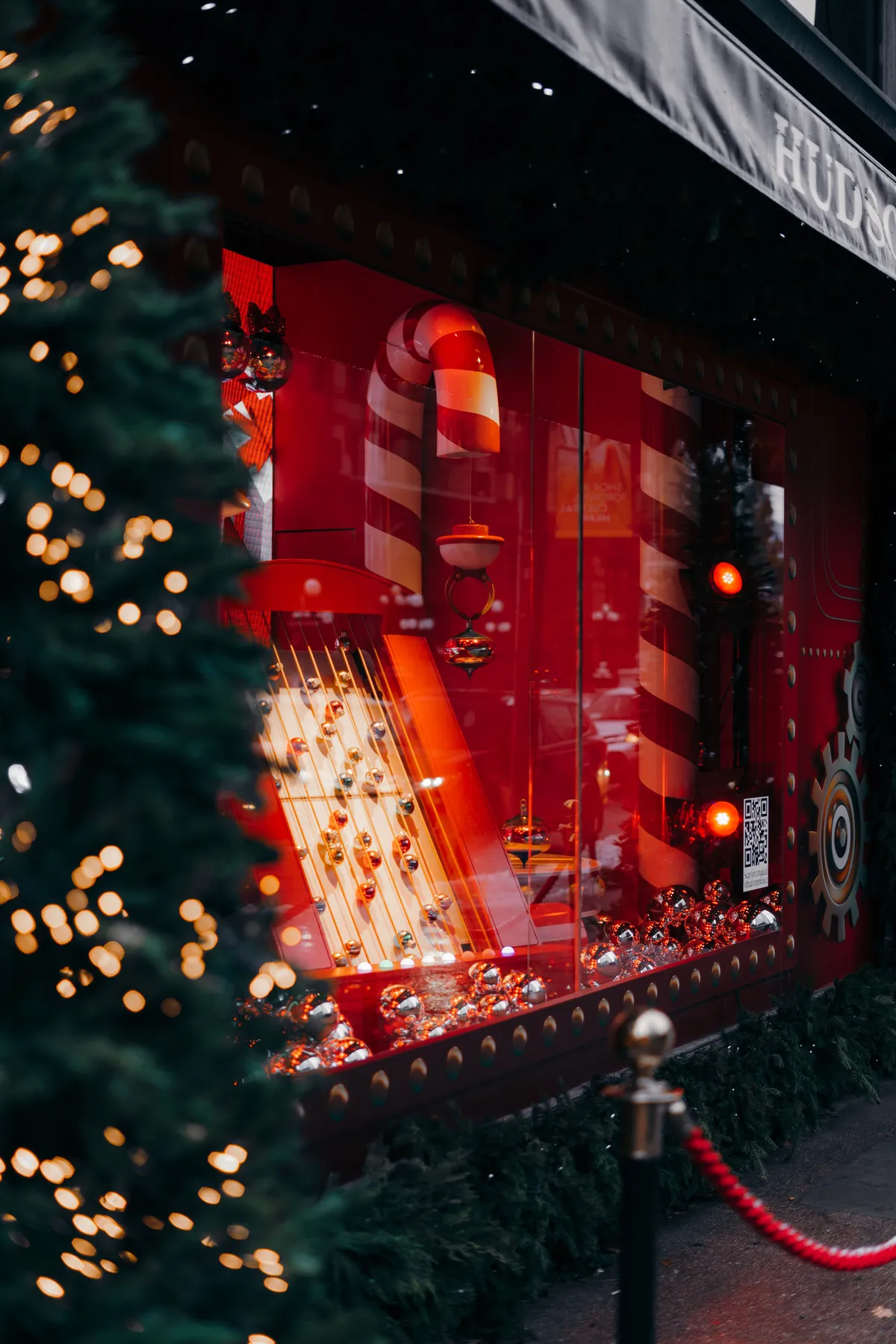 A vibrant red Christmas window display with candy cane decor and festive lights.