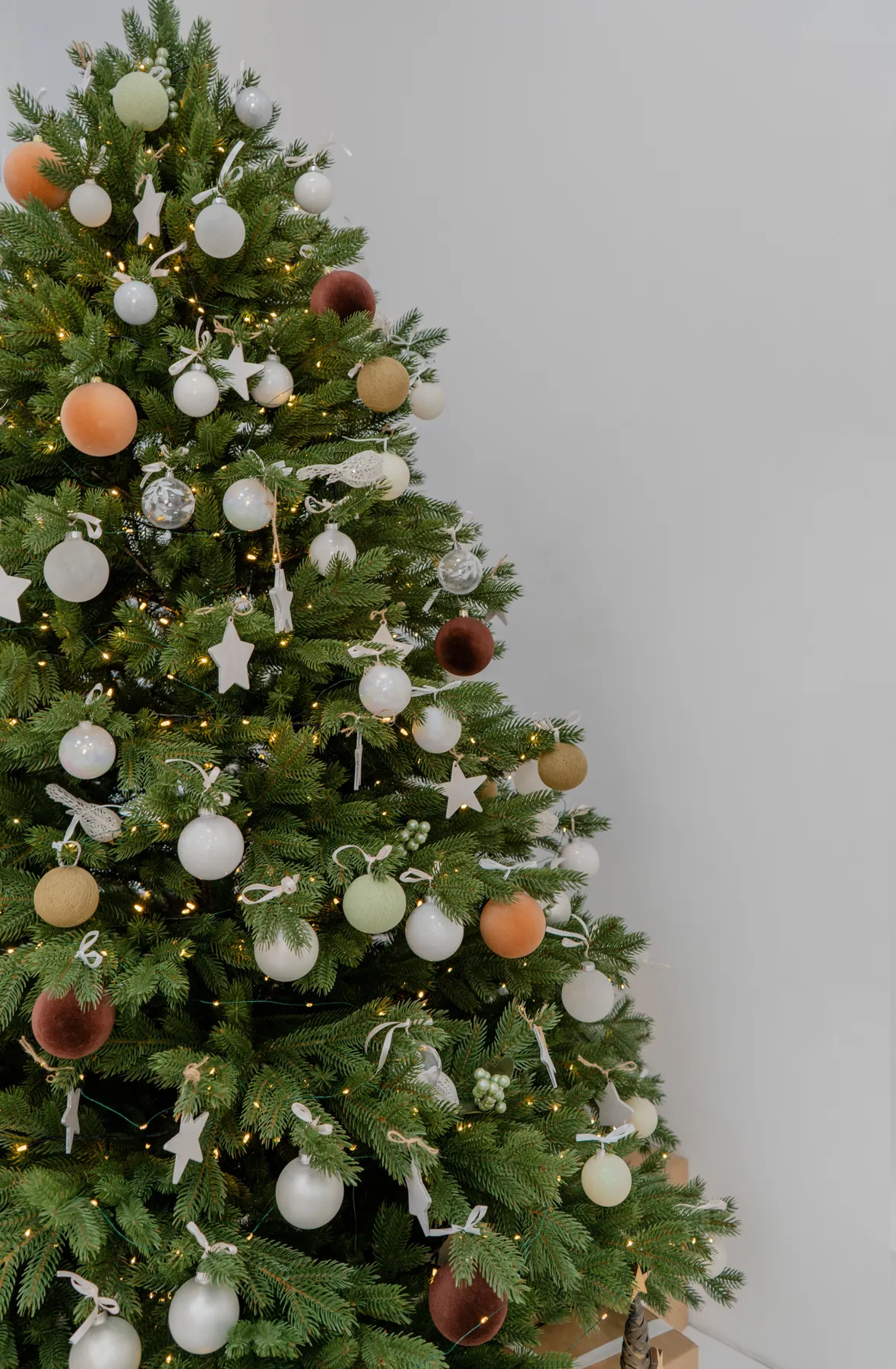Beautifully decorated Christmas tree with elegant ornaments and soft lighting indoors.