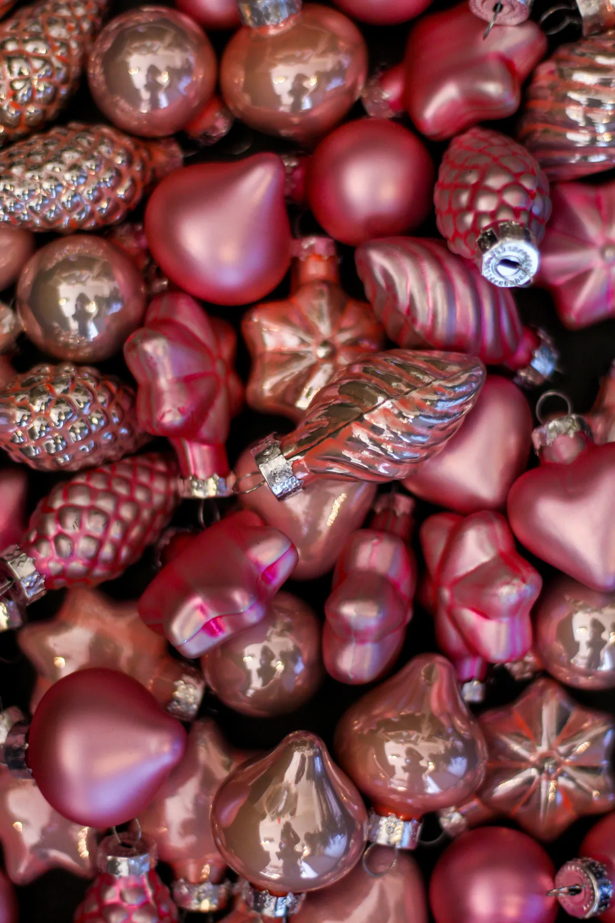 Bright pink and silver Christmas ornaments in various shapes.