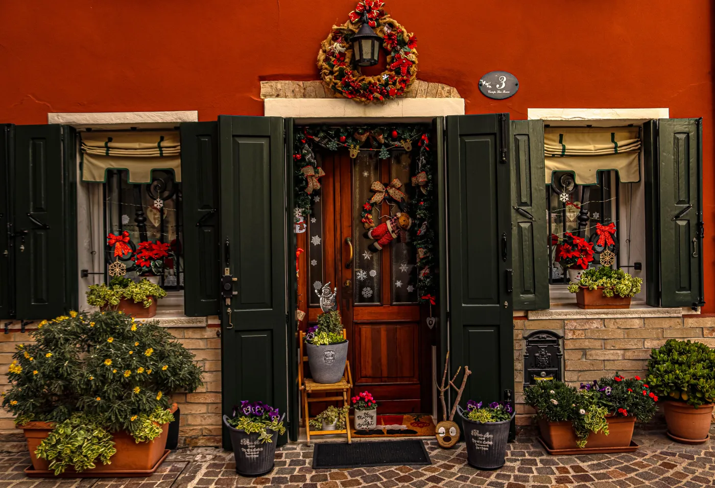 Charming doorway adorned with Christmas wreaths and cheerful decorations.