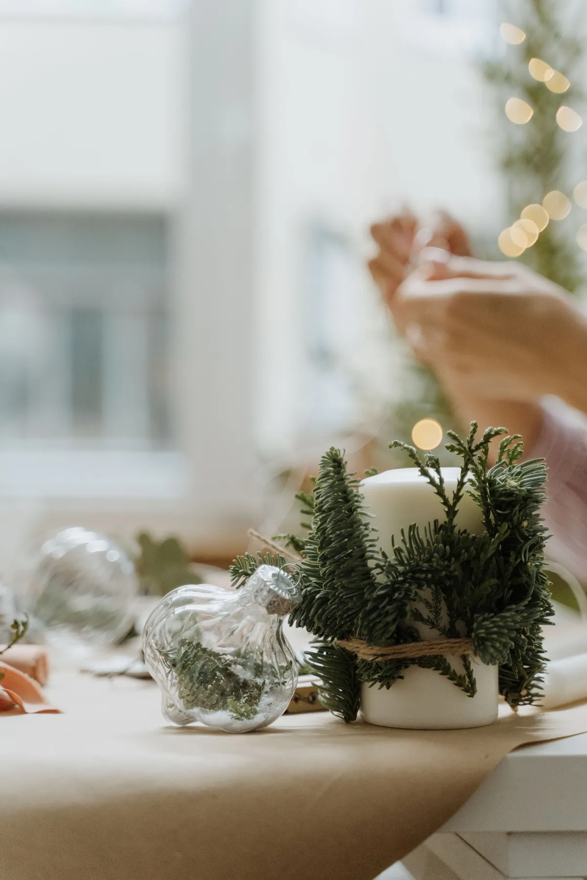 Close-up of a festive candle decorated with conifer twigs, perfect for Christmas ambiance.