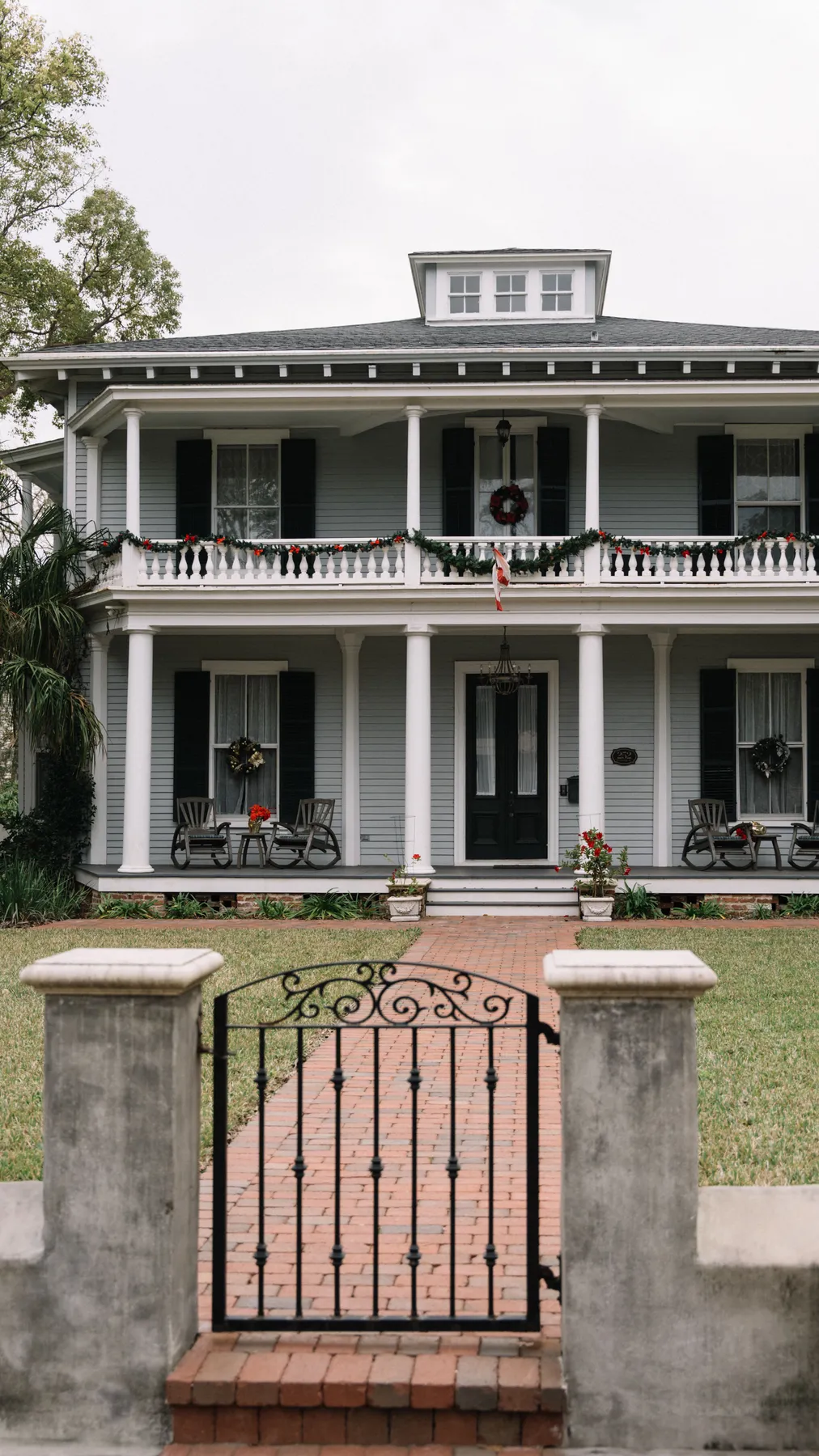 Colonial-style home in St. Augustine, FL, adorned with Christmas decorations, captured during the day.