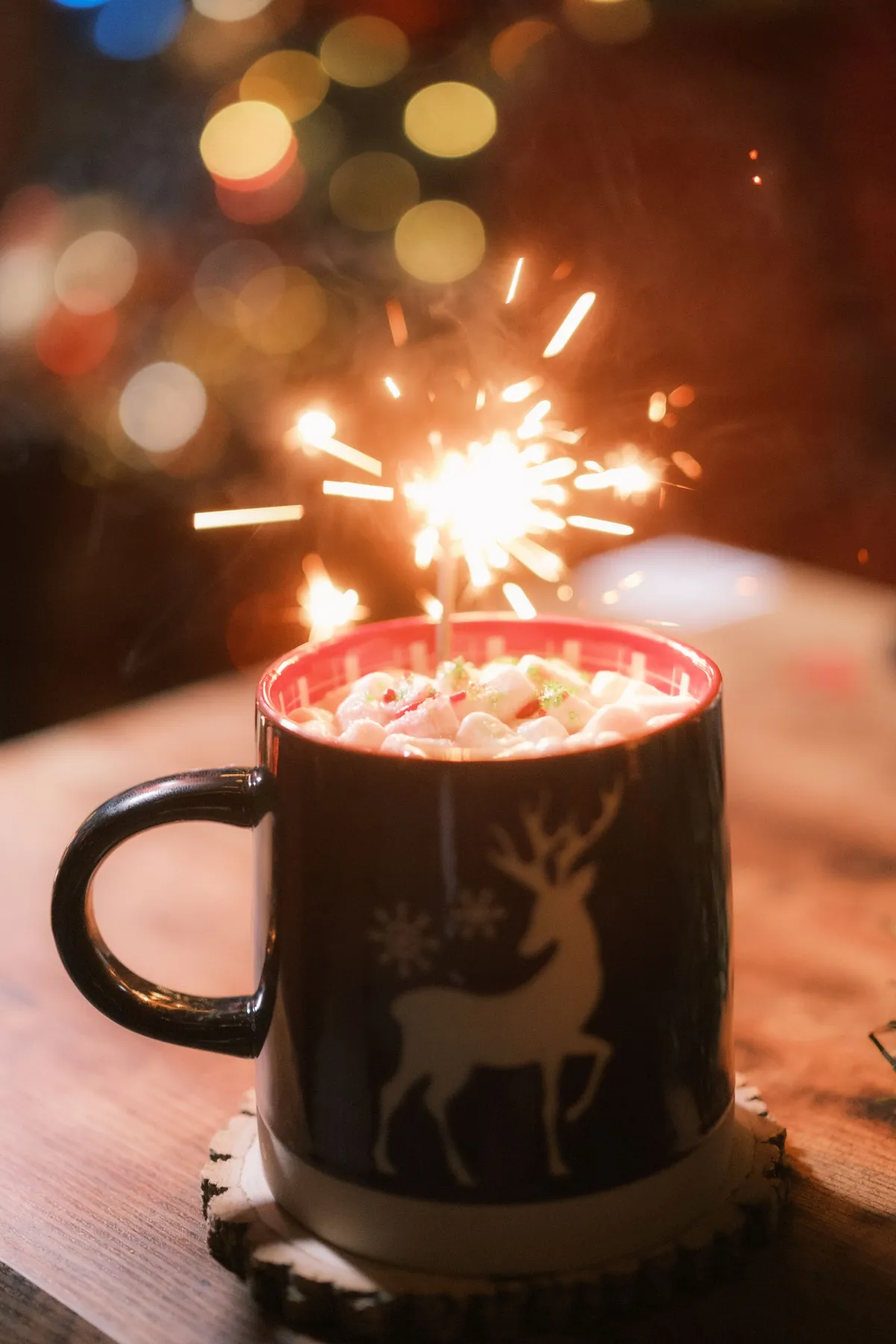 Cozy holiday hot chocolate mug with marshmallows and a sparkler, perfect for festive celebrations.