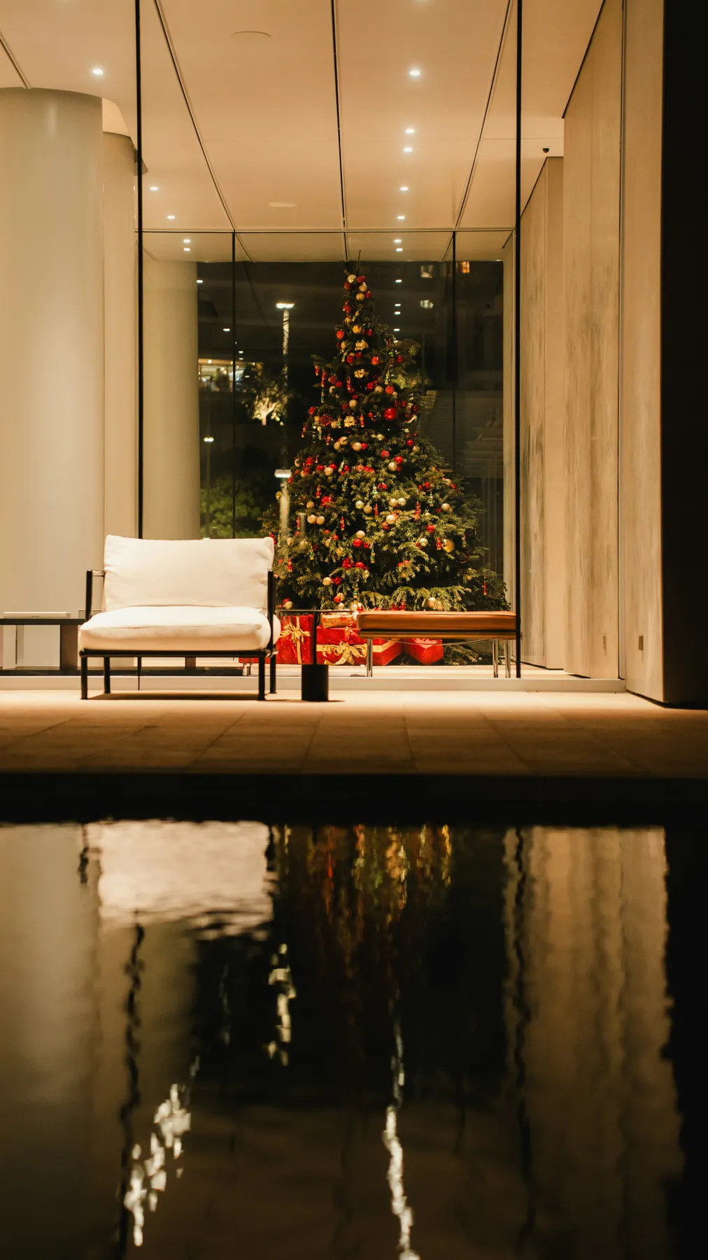 Decorated christmas tree reflected in water with water