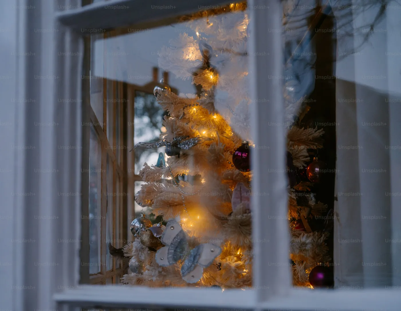 Decorated christmas tree with lights seen through window. photo – Christmas  Image on Unsplash