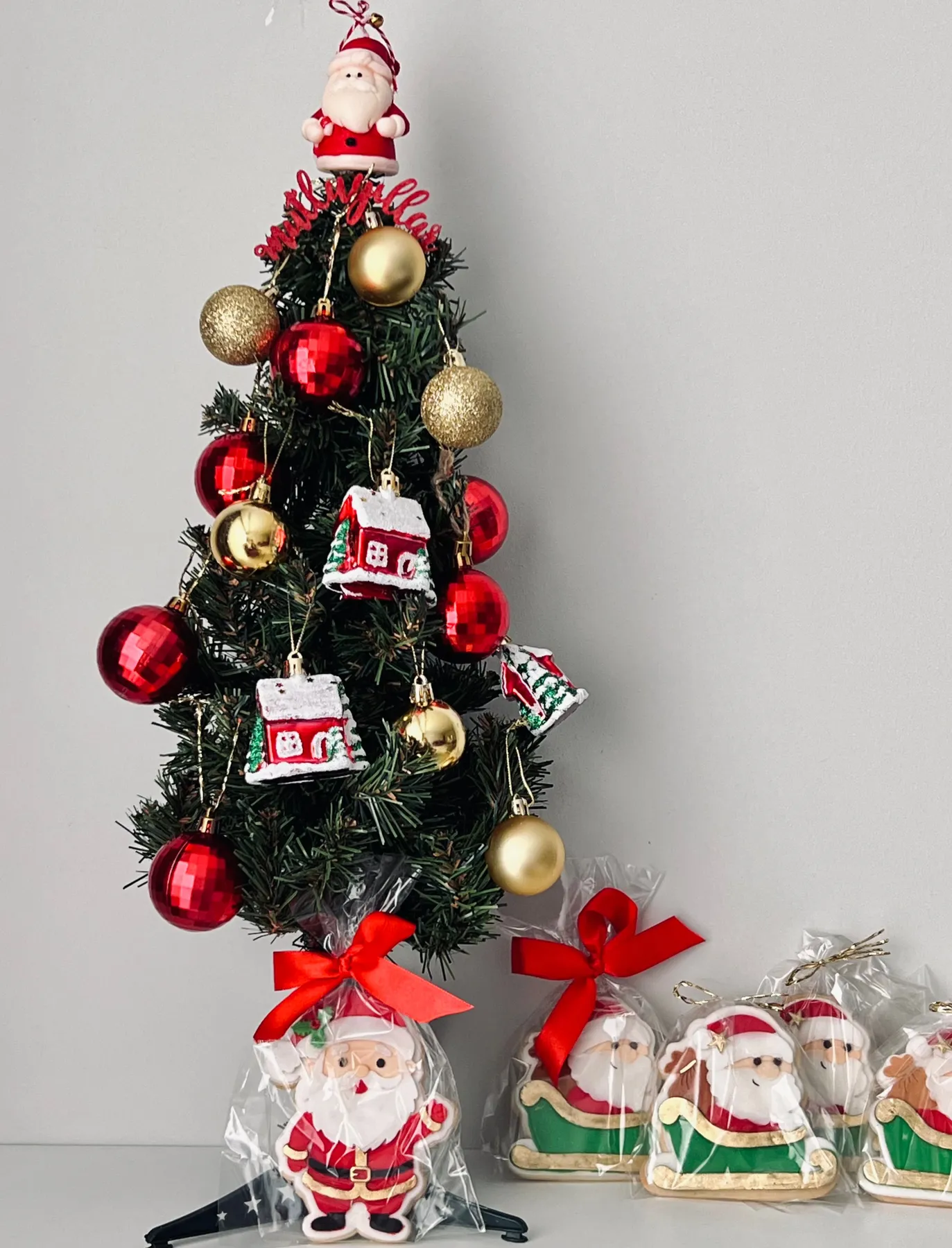 Decorated Christmas tree with Santa ornaments and gifts, perfect for holiday cheer.