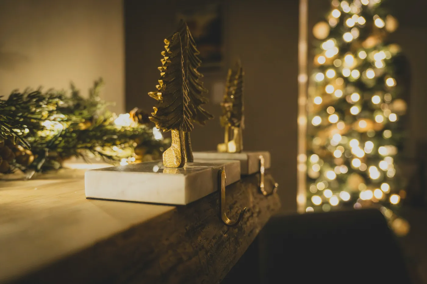 Decorative christmas trees on a mantelpiece with bokeh lights