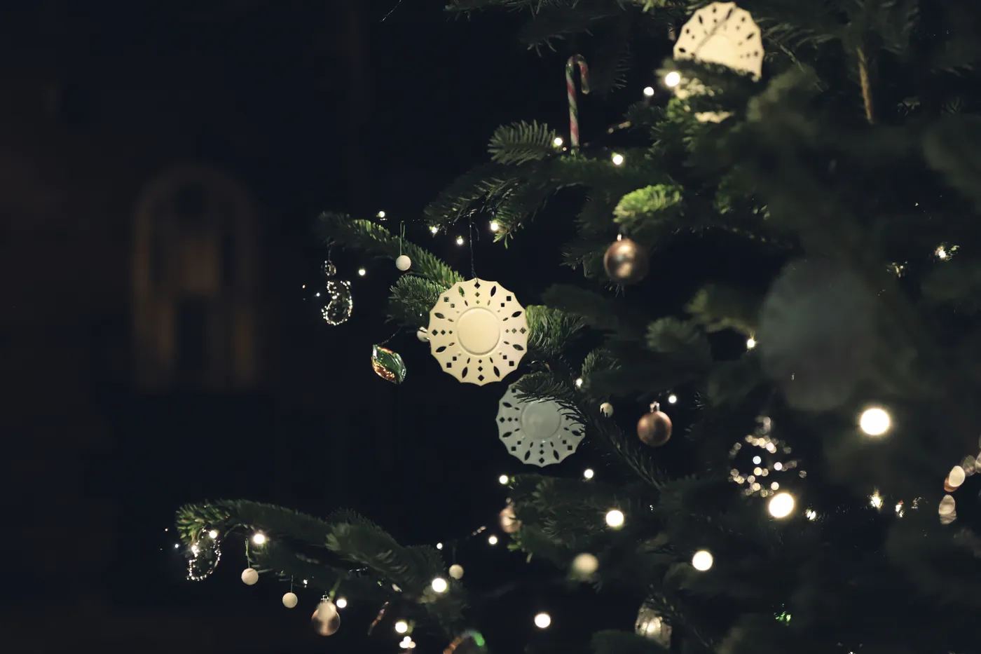 Elegant Christmas tree with lights and ornaments beautifully illuminated at night.