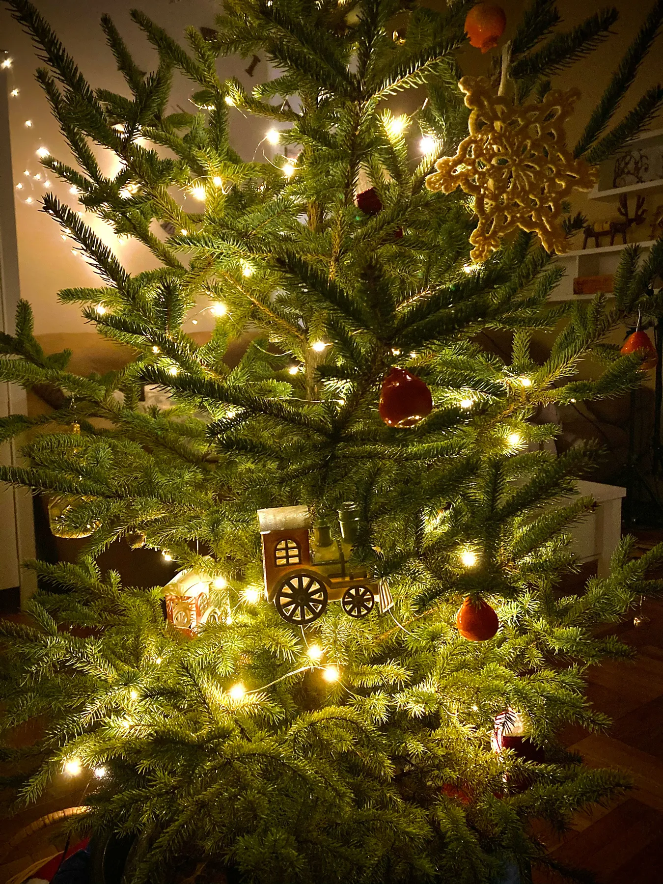 green christmas tree with red baubles and string lights