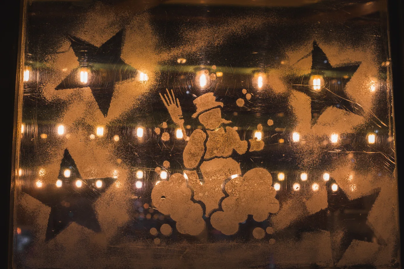 Illuminated Christmas window with festive lights and snowman design in Munich.