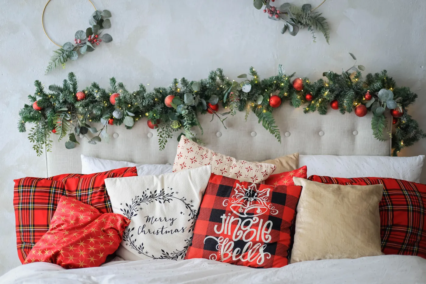 Inviting bedroom decorated with Christmas pillows and garlands for a festive holiday feel.