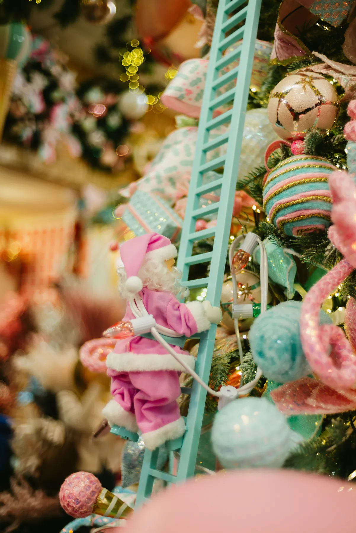 Santa climbing a ladder on a decorated christmas tree