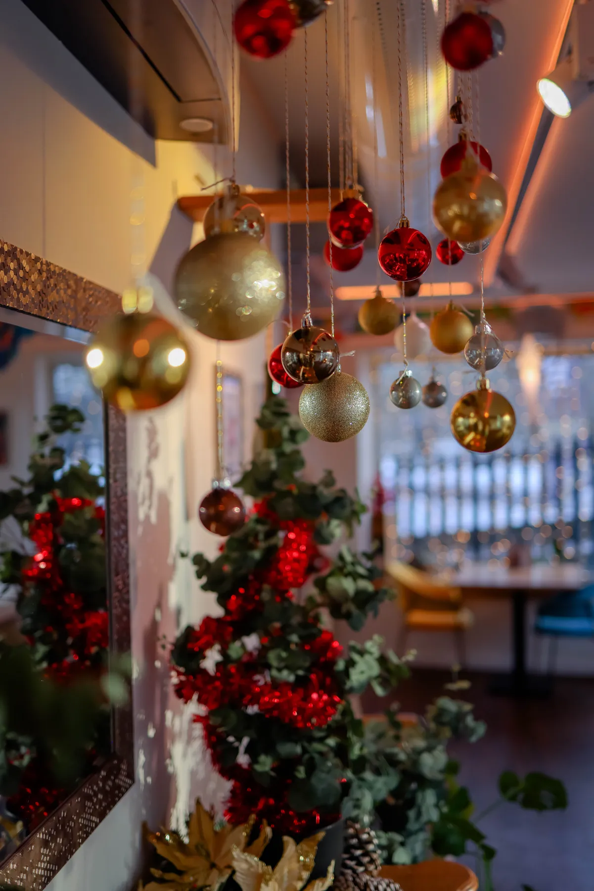 Warm and cozy indoor Christmas decorations with hanging baubles and tree.