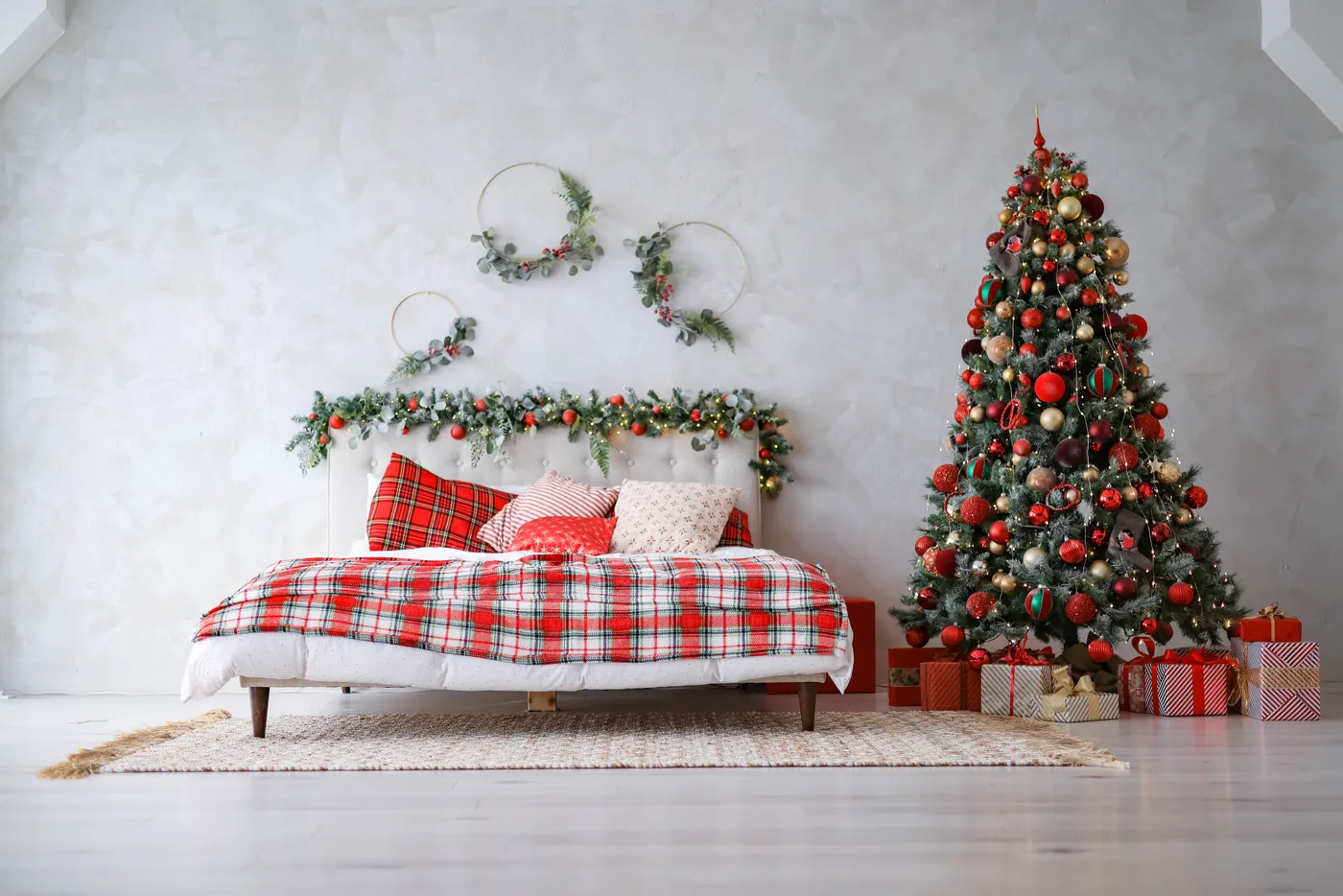 Warm and inviting Christmas-themed bedroom featuring a decorated tree and cozy bed.
