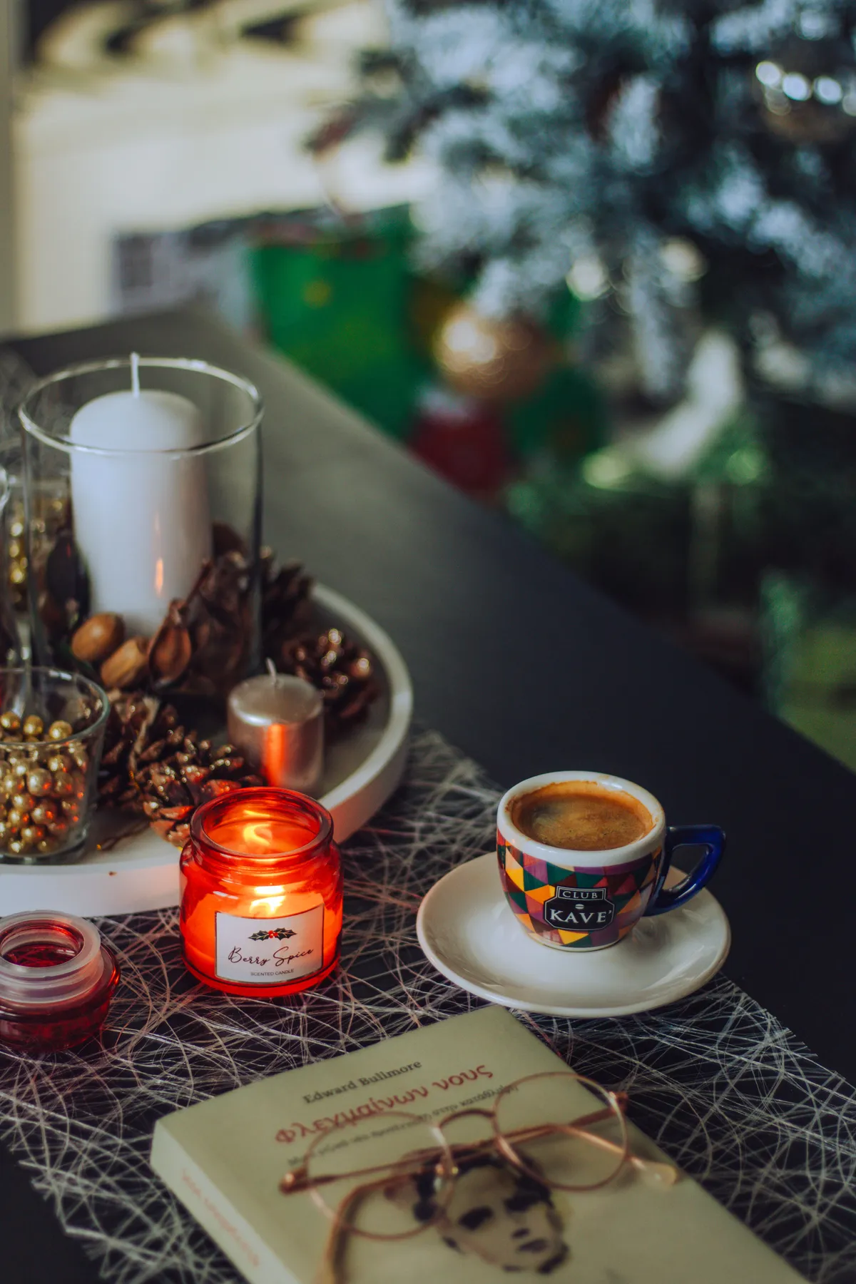 Warm and inviting table with coffee, candles, and holiday decor, perfect for a cozy winter setting.