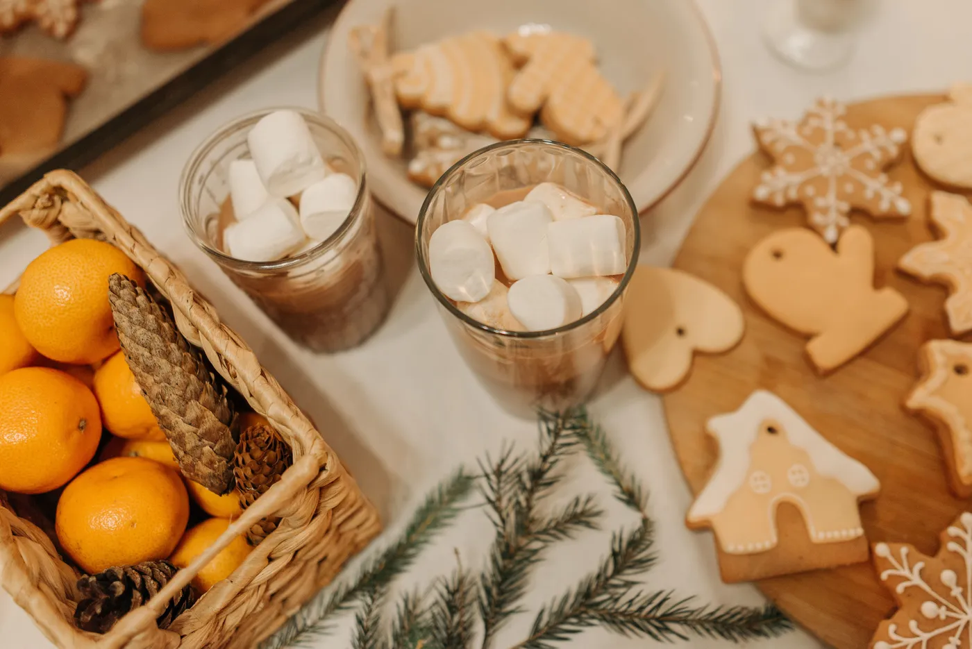 Warm Christmas scene featuring gingerbread cookies and hot cocoa with marshmallows.