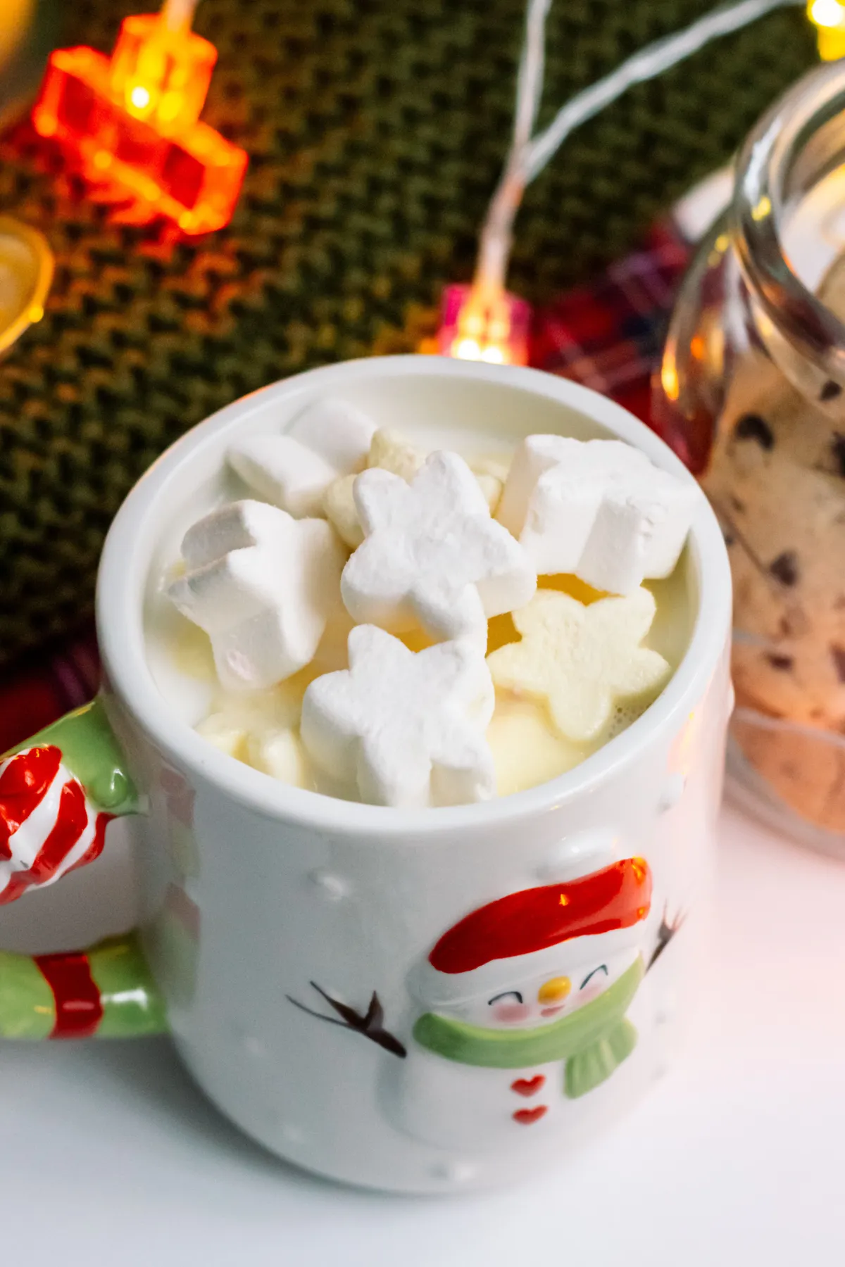 Warm mug of hot chocolate topped with snowflake marshmallows, perfect for winter holidays.