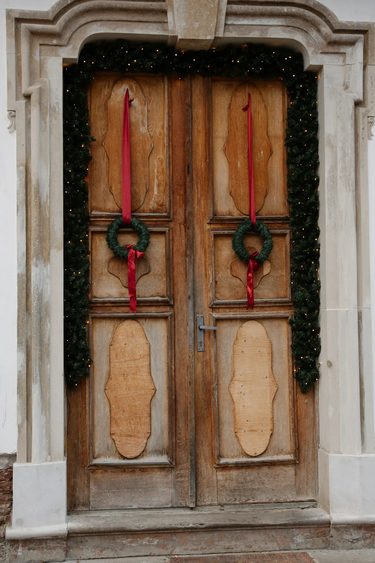 Wooden doors decorated with christmas wreaths and lights
