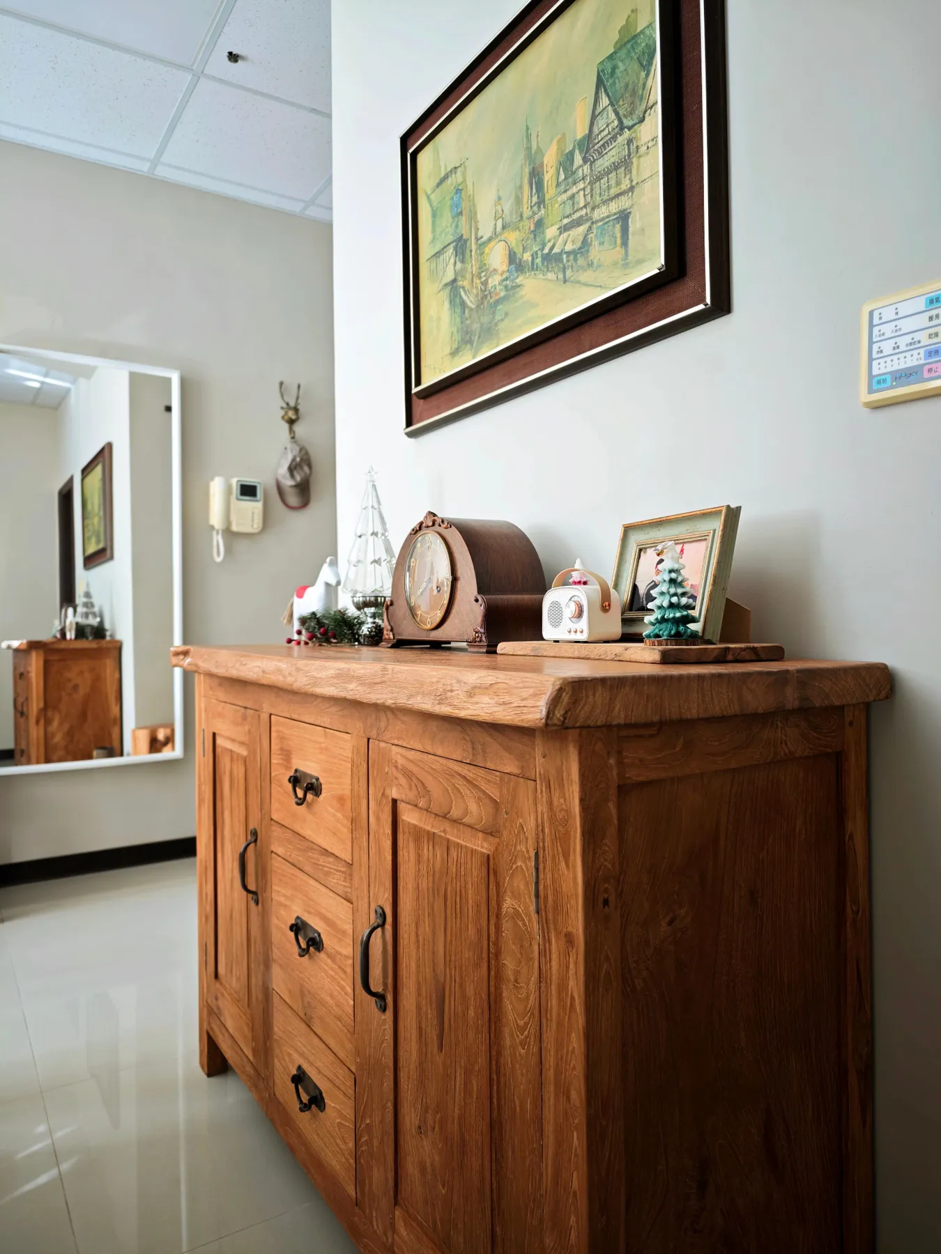 Wooden sideboard with elegant decor and framed artwork in a contemporary room setting.